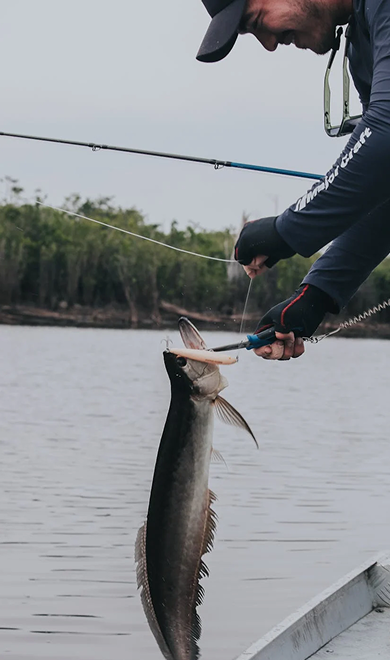 Photo of someone holding a fish and cutting the fishing rope in Lombok with Magic Fishing