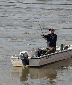 Photo of a someone fishing from a little boat